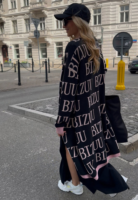 Modelka na ulicy ubrana w czarny kardigan w logo CHIOS.