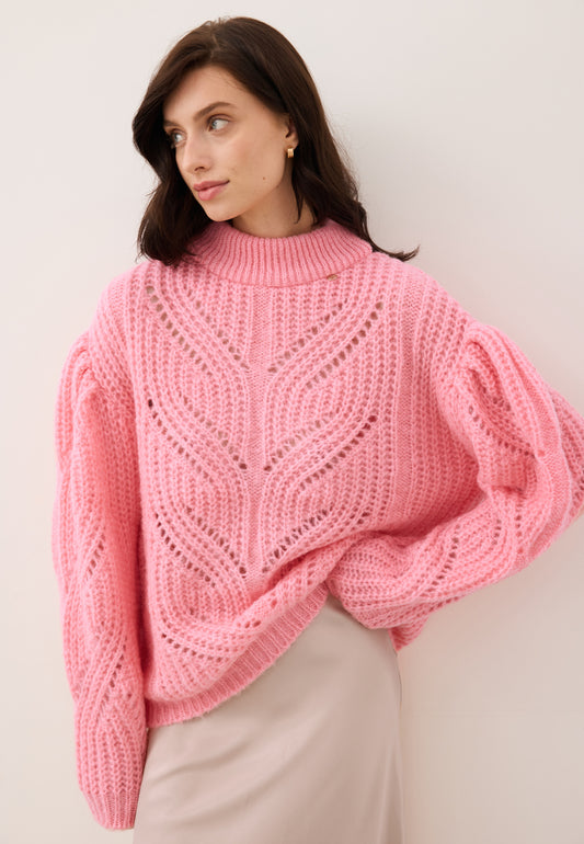 Modelka z ręką trzymającą przód ażurowego swetra ROSSO różowego.