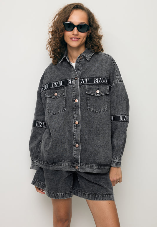 Modelka ubrana w jeansową kurtkę w kolorze szarym PASSA z logowaną taśmą