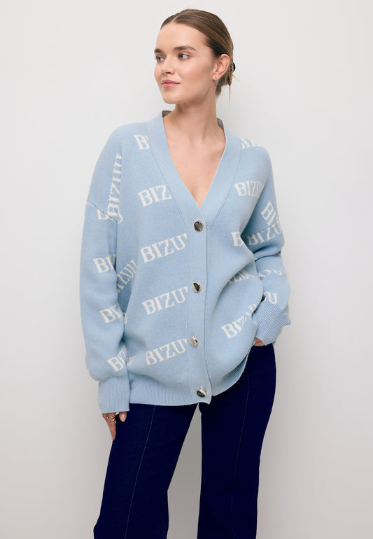 Modelka z jedną ręką w kieszeni spodni ATLANTA, ubrana w błękitny sweter KYLE w logo.