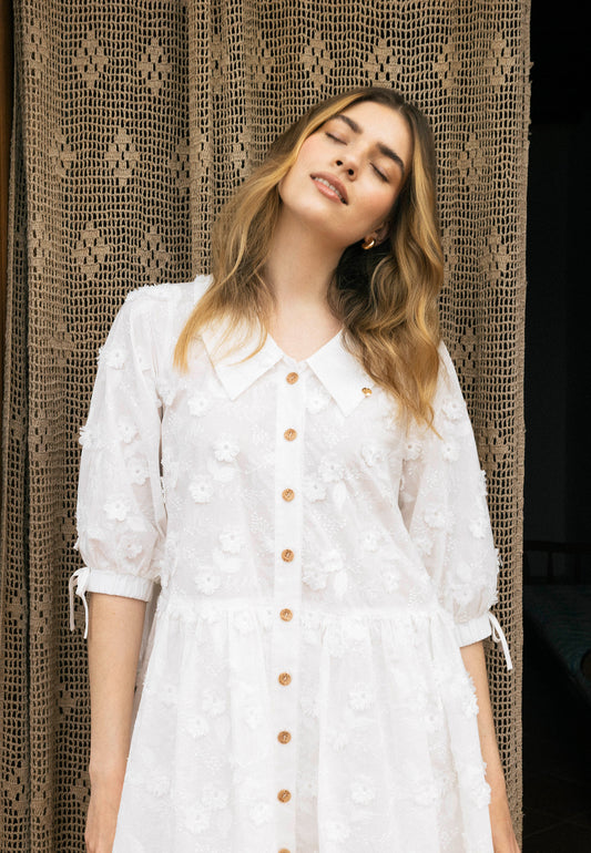 Zbliżenie na modelkę stojącą z zamkniętymi oczami i przechyloną głową. Ubrana w luźną sukienkę VIKKA.