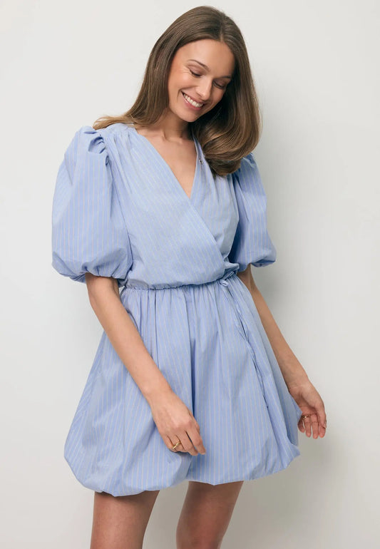 Uśmiechnięta modelka w mini sukience z kopertowym dekoltem CELESTA.