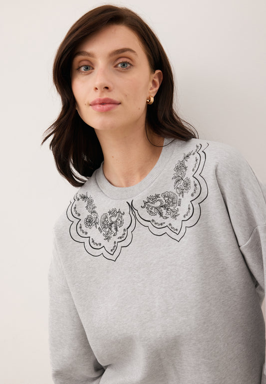 Zbliżenie na modelkę ubraną w szarą bluzę COLLIER z narysowanym kołnierzykeim.