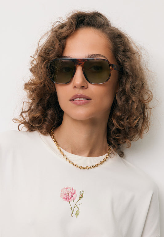 Zbliżenie na modelkę w okularach przeciwsłonecznych z szylkretową oprawką MISTRETTA.