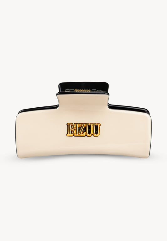 Prostokątna klamra do włosów IVORIA z czarnymi elementami i złotym logo.