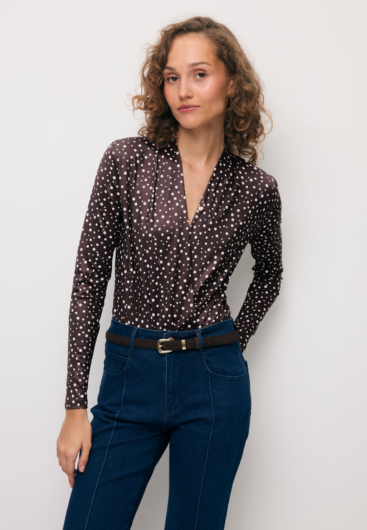 Modelka z jedną ręką z tyłu ubrana w kopertowe body w kropki LOMMA.