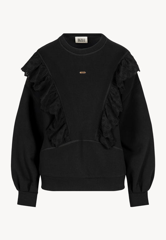 Przód czarnej bluzy LOYA z ozdobną, koronkową falbanką na przodzie.