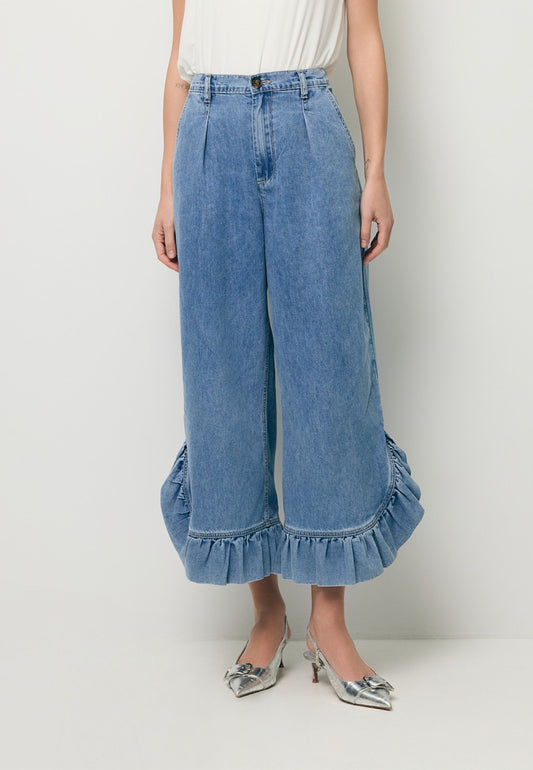 Zbliżenie na nogi modelki w jeansowych spodniach z ozdobnymi falbanami NELLA.