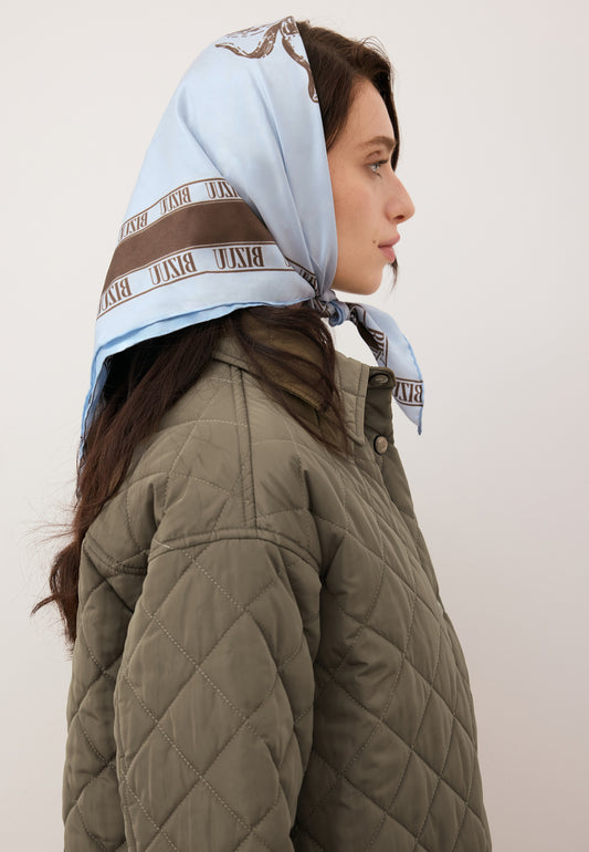 Modelka w niebieskiej, jedwabnej apaszce ARIA przewiązanej na głowie.