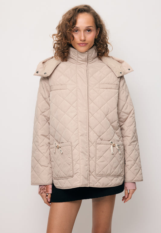 Modelka ubrana w pikowaną kurtkę NAYLA z odpinanym kapturem.