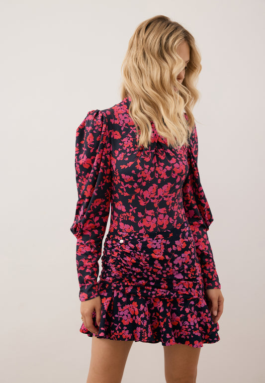 Modelka patrząca w dół, ubrana w asymetryczną mini spódniczkę MEXICANA oraz body z przepleceniem PINGANG.