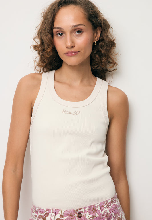 Zbliżenie na modelkę ubraną w biały top z beżowym logo LOVIE.