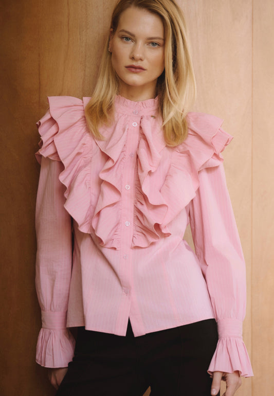 Zbliżenie na modelkę ubraną w różową koszulę z falbanami SANNI.