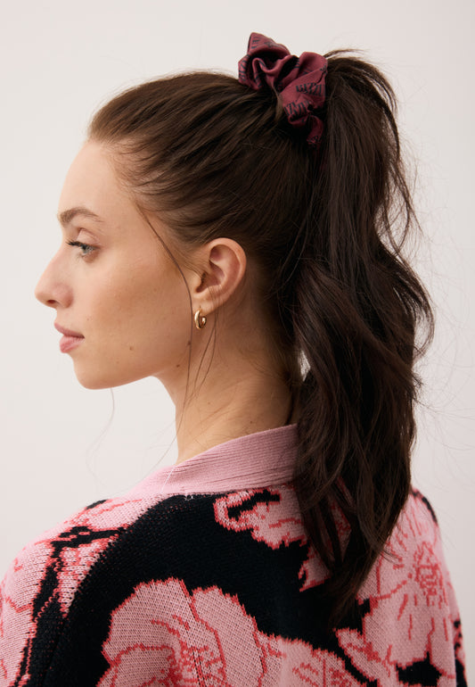 Zbliżenie na włosy modelki związane w koński ogon przy pomocy jedwabnej gumki SILKY w kolorze bordowym.