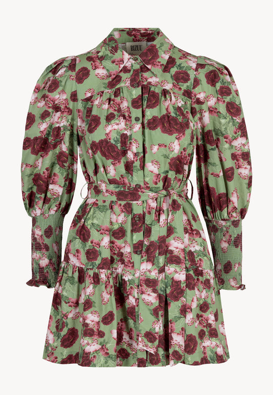 Zbliżenie na modelkę ubraną w zieloną mini sukienkę SOREZIA w kwiatowy print.