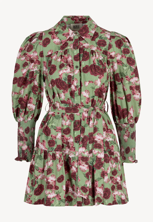Zbliżenie na modelkę ubraną w zieloną mini sukienkę SOREZIA w kwiatowy print.