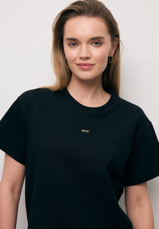 Zbliżenie na modelkę w czarnym T-shircie TISHAL z logo na przodzie.
