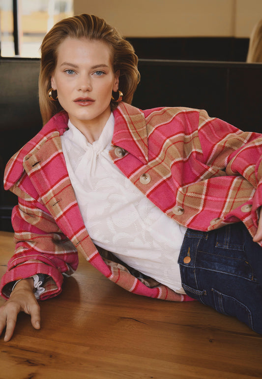 Modelka w różowym płaszczu w kratkę z logo na rękawie WIVINA.