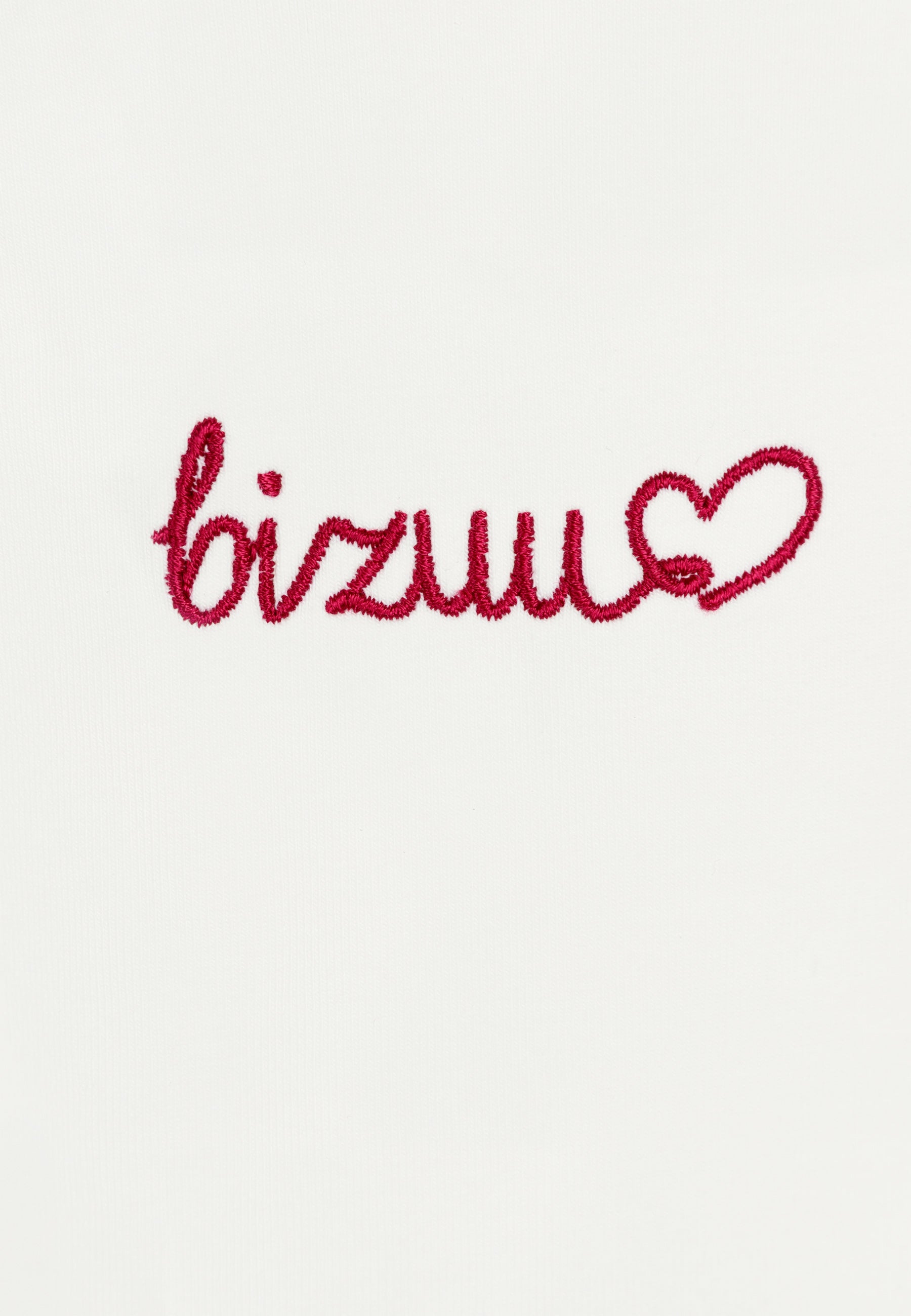 Zbliżenie na czerwone logo Bizuu zakończone serduszkiem umieszczone na przodzie T-shirtu SEYA.