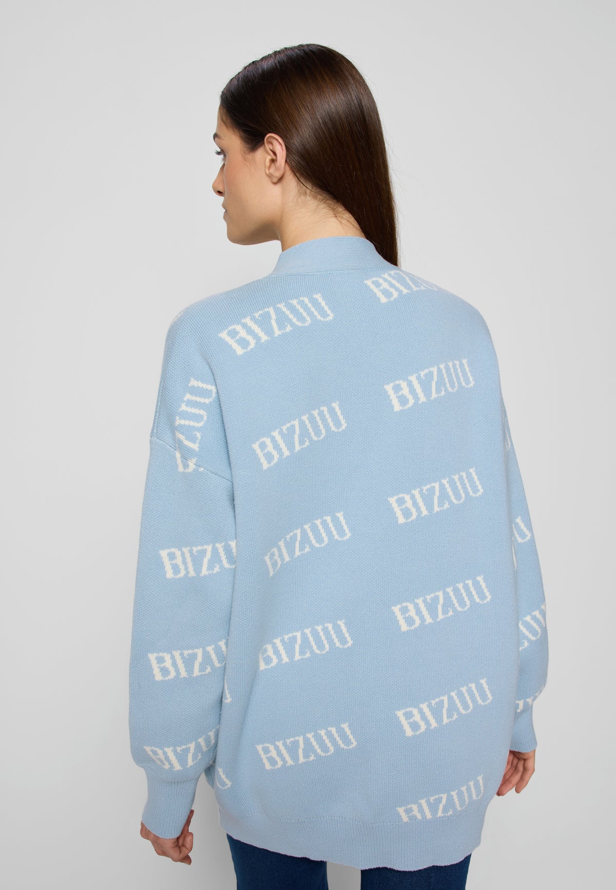 Zbliżenie na tył błękitnego swetra w logo Bizuu na modelce.