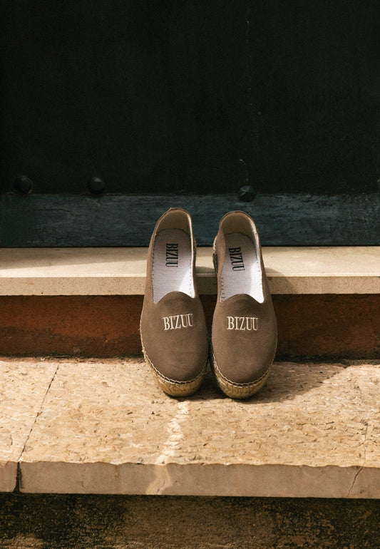 Espadryle z logo Bizuu oparte o schodek.