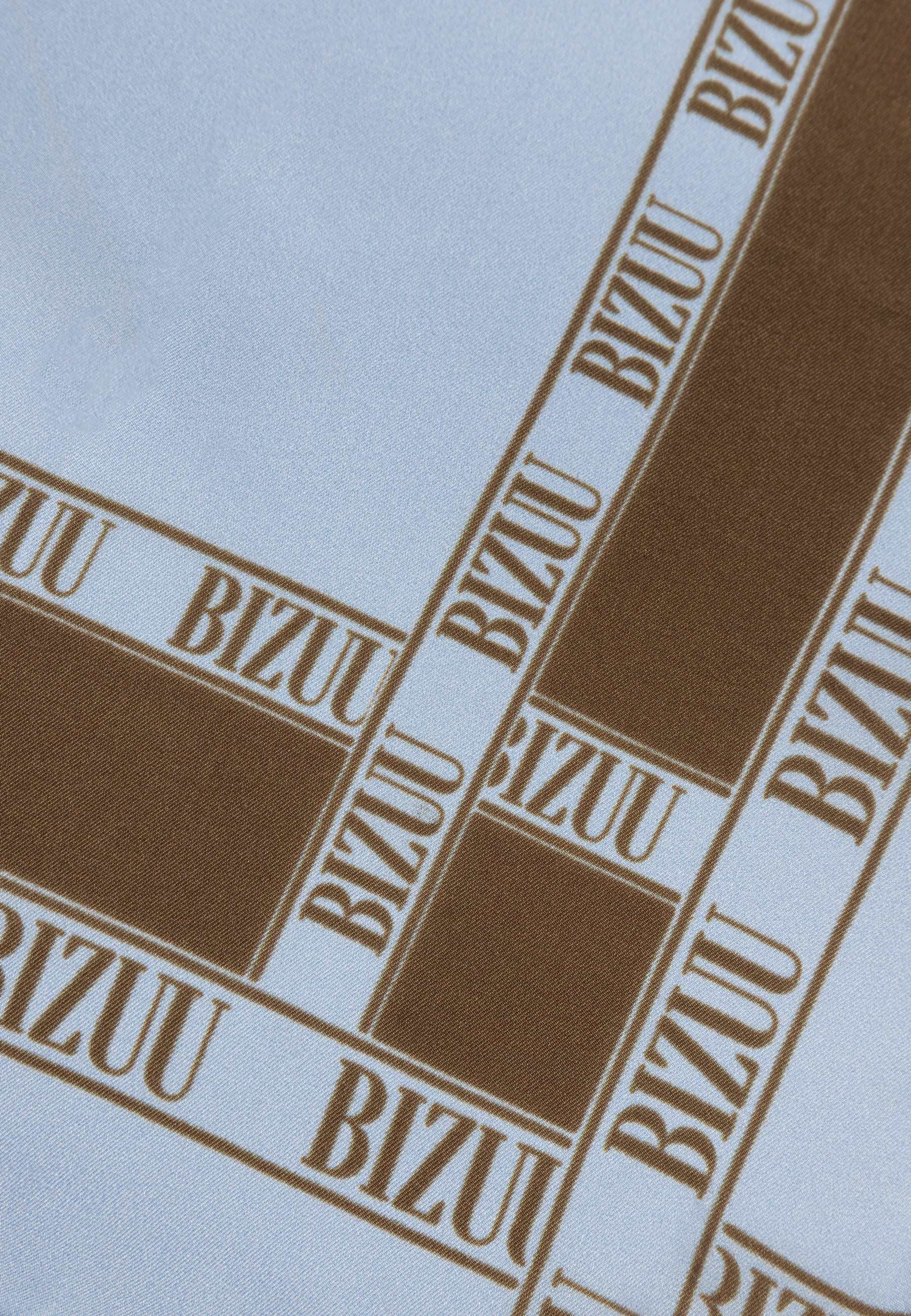 Zbliżenie na brązowe logo na niebieskiej, jedwabnej apaszce ARIA.