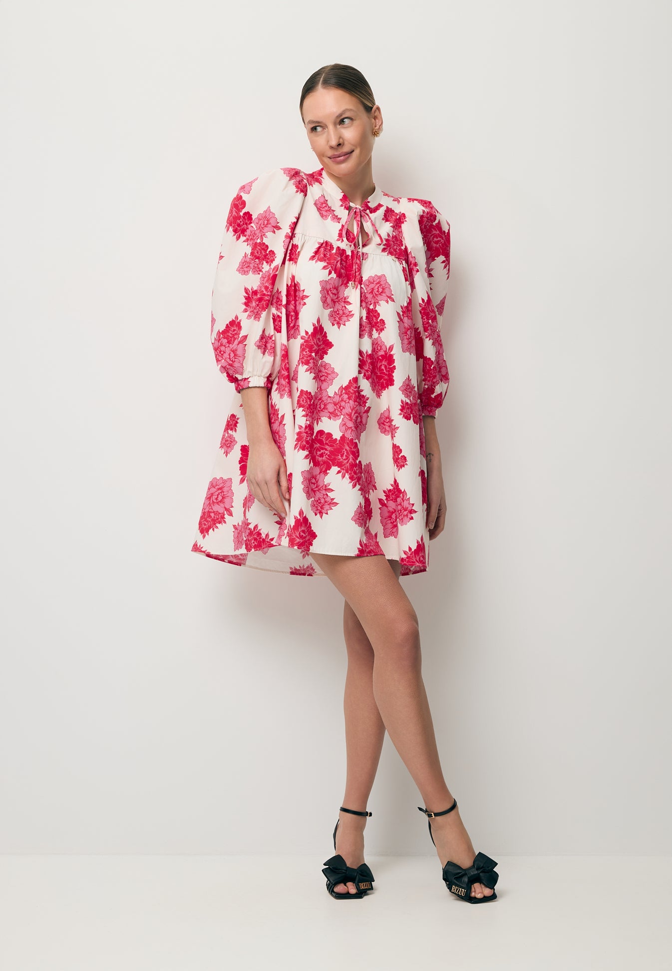 Modelka w mini sukience w kwiatowy print AYOTE oraz buty LAVILLY.