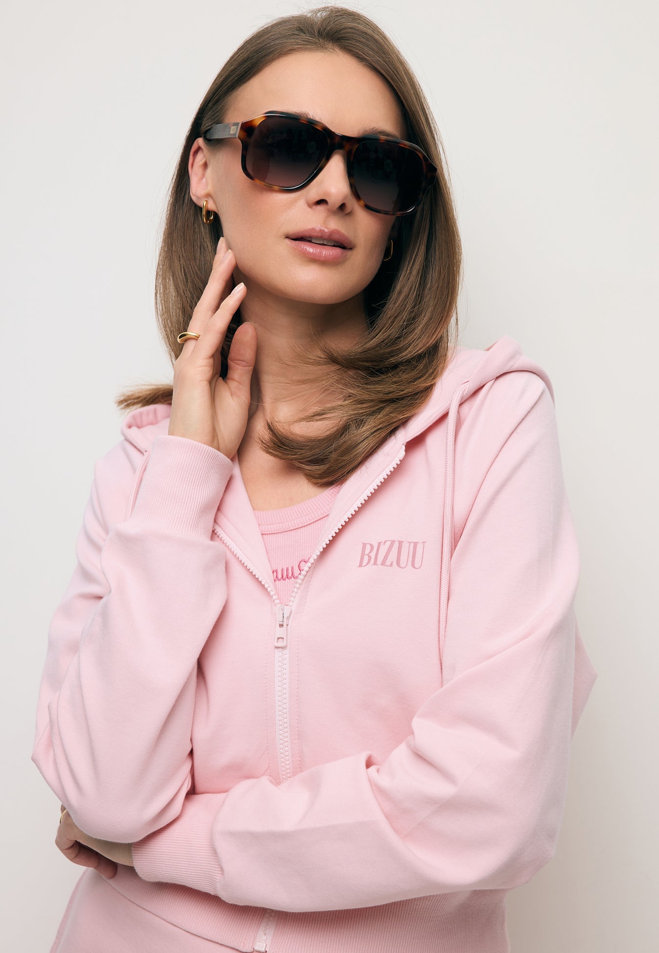 Zbliżenie na modelkę w rozpinanej różowej bluzie dresowej CIANA.