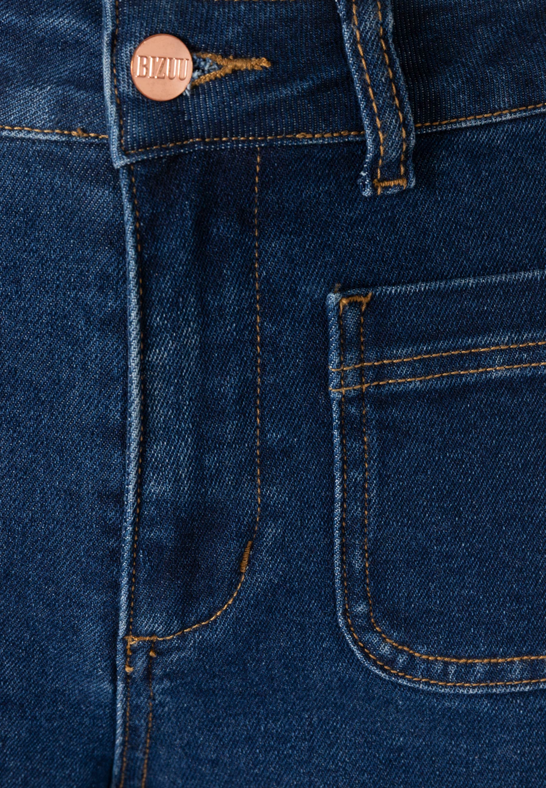 Zbliżenie na zamek i przednią kieszeń granatowych jeansów DELPHI.