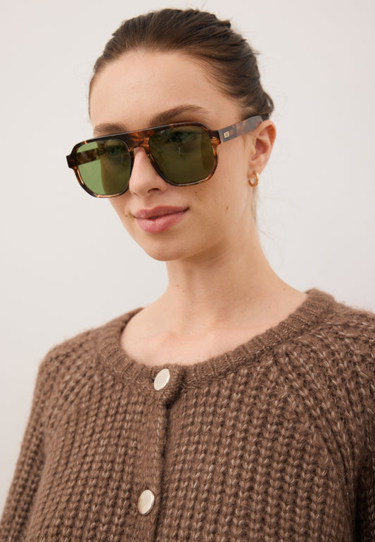 Zbliżenie na modelkę w okularach przeciwsłonecznych z szylkretową oprawką MISTRETTA.
