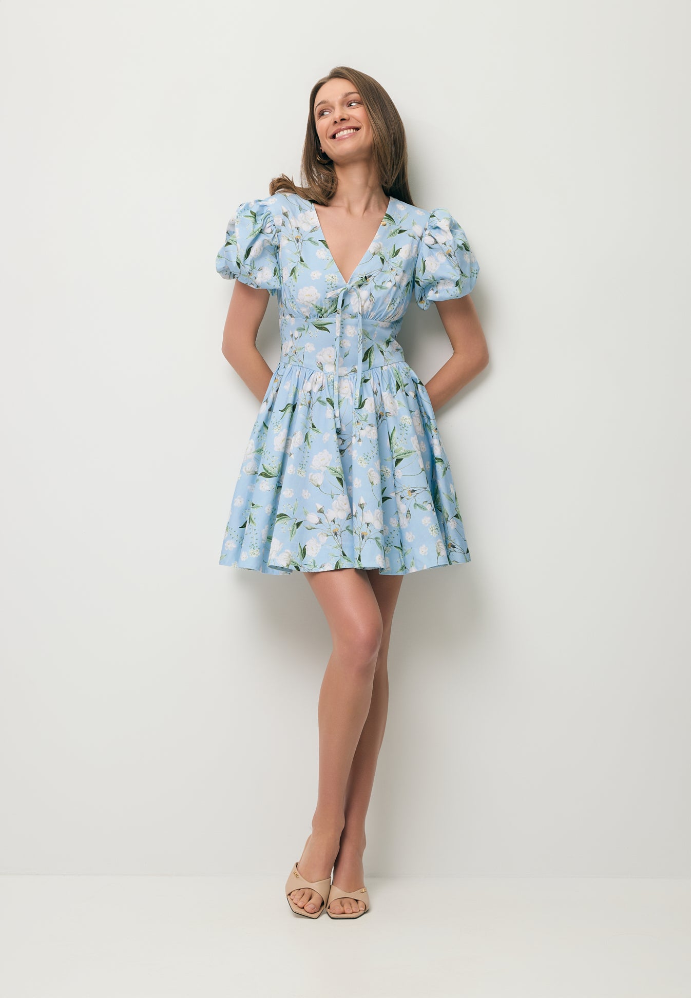 Uśmiechnięta modelka w mini sukience w niebieski kwiatowy print EVIANNE.
