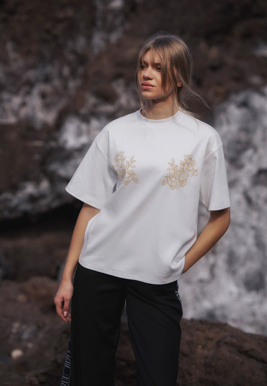 Zbliżenie na modelkę w kremowym T-shircie z autorską aplikacją FANYA.