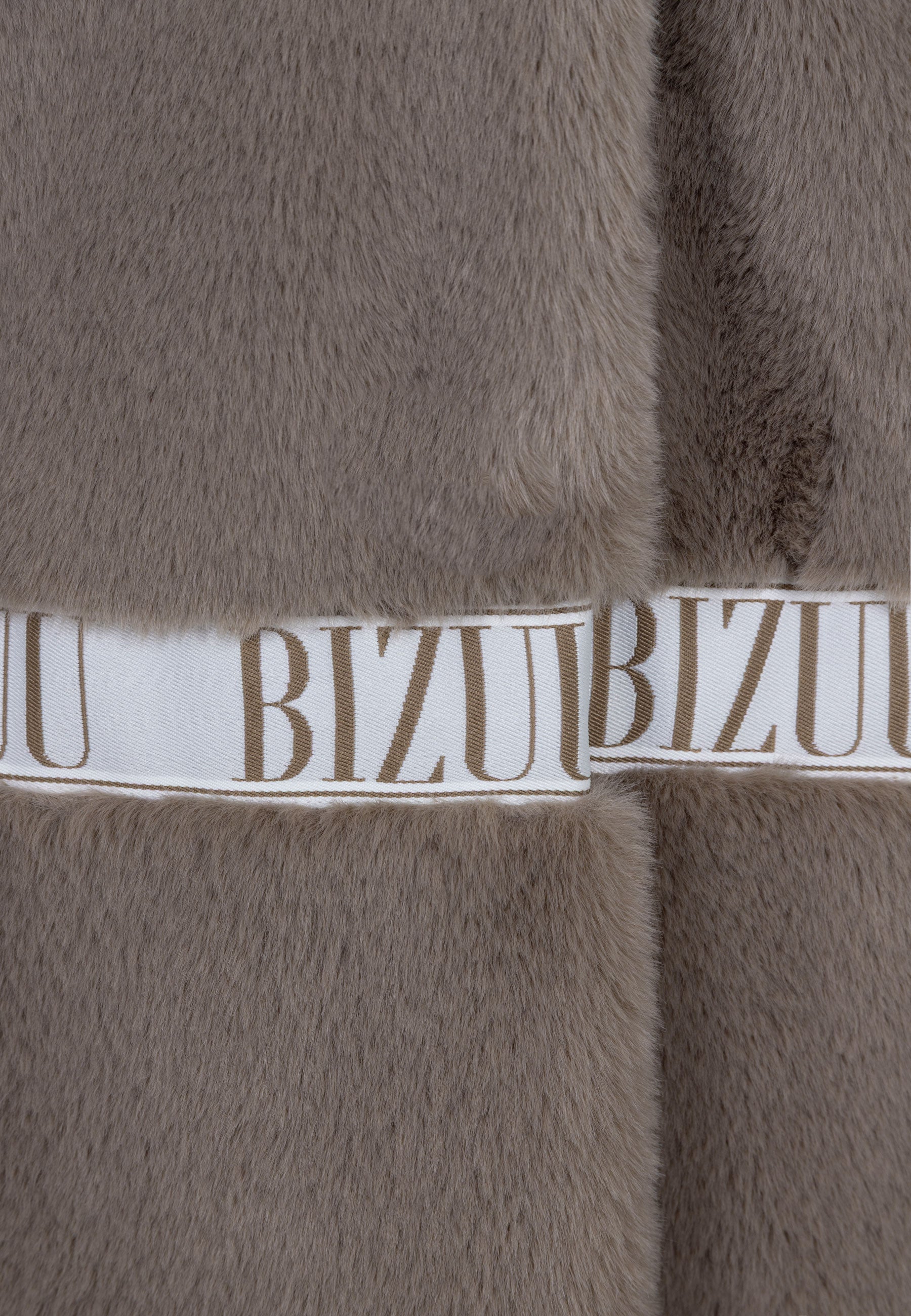 Zbliżenie na logowaną taśmę na futrze FLORENCE taupe.