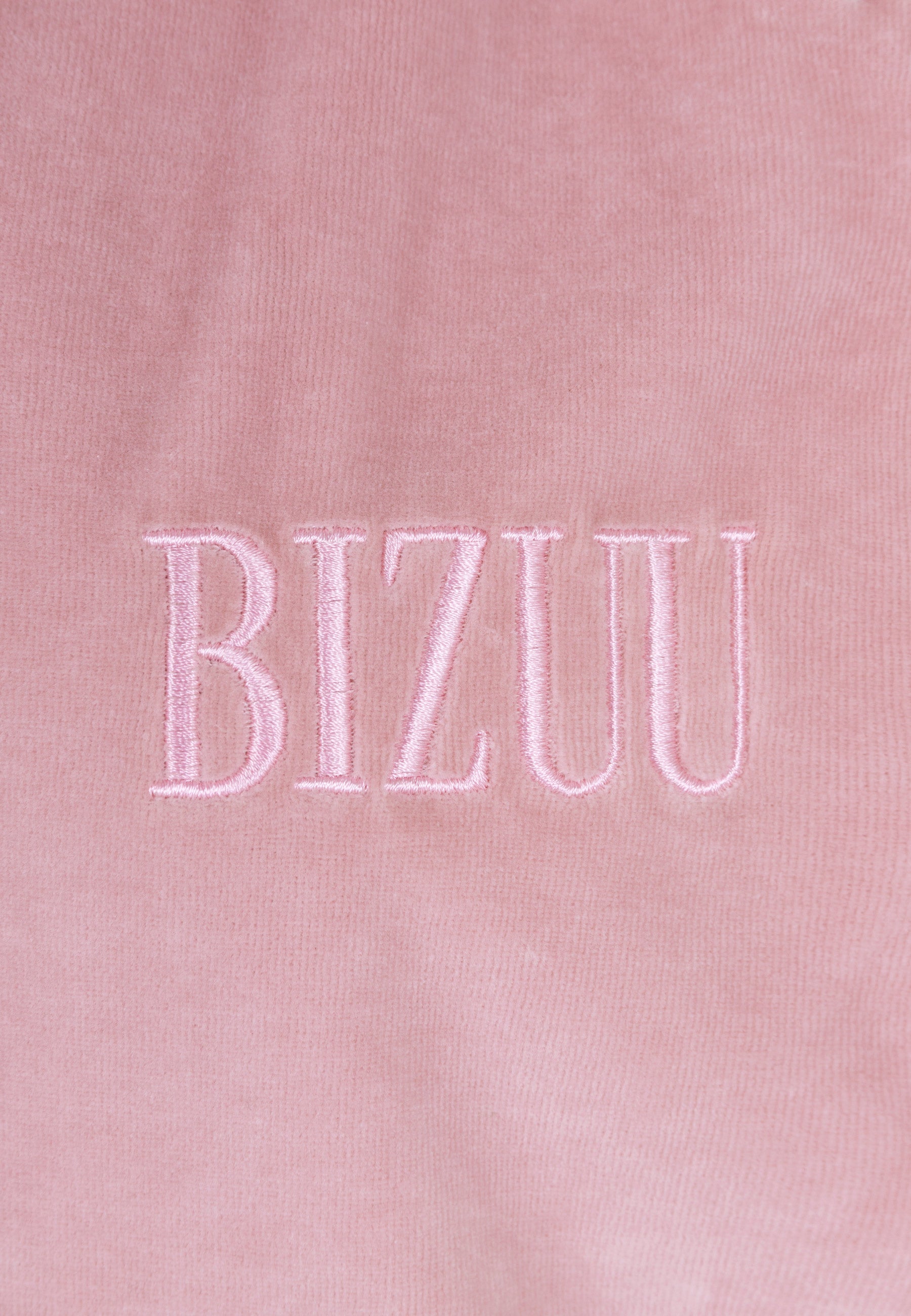 Zbliżenie na haftowane logo Bizuu na przodzie bluzy IANELLA.