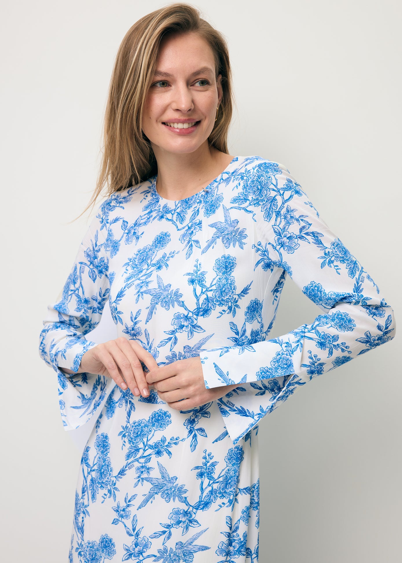 Zbliżenie na modelkę prezentującą ozdobny rękaw w sukience w niebieski print IVYNI.