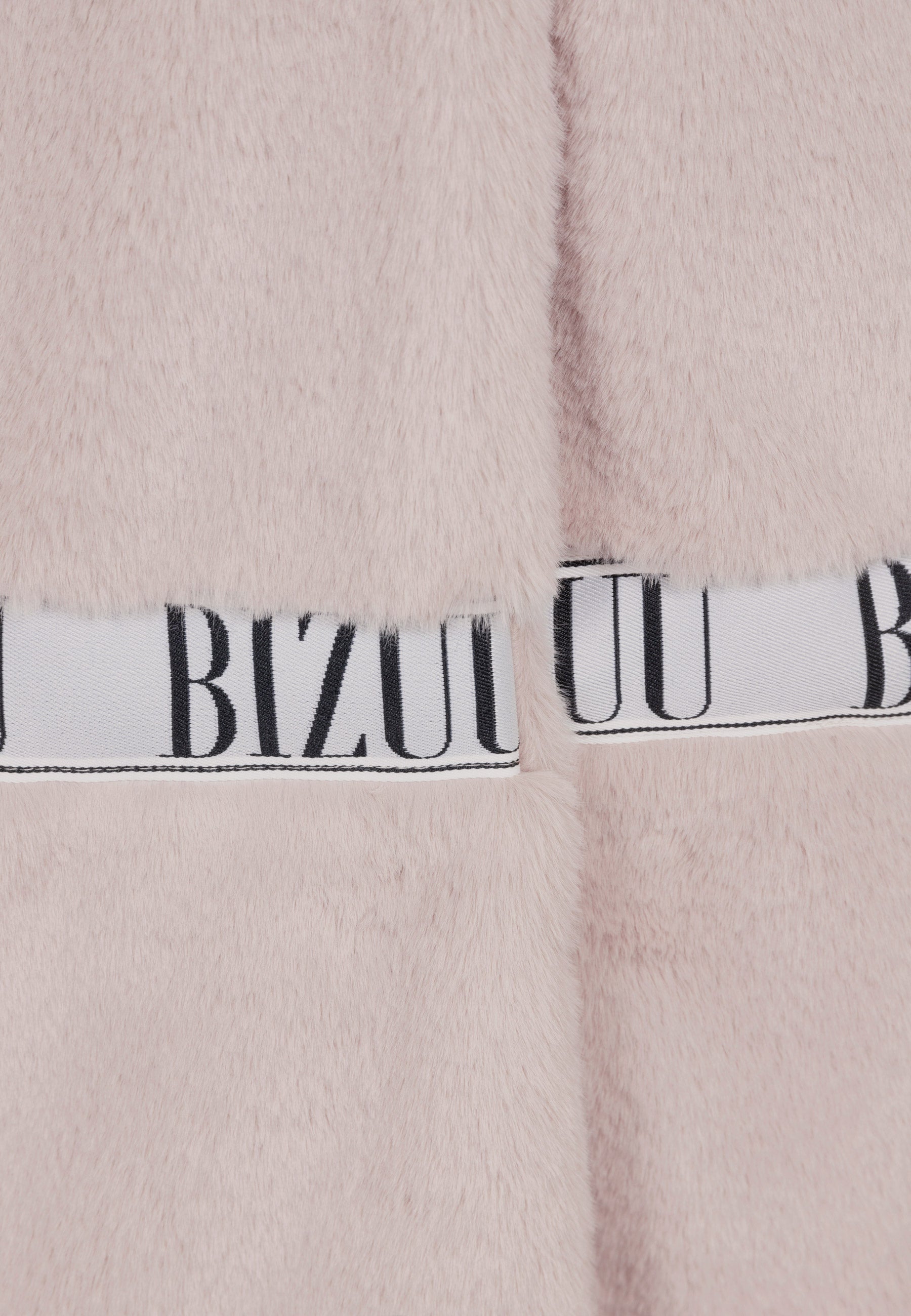 Zbliżenie na logowany lampas na futerku MILANO w kolorze beżowym.