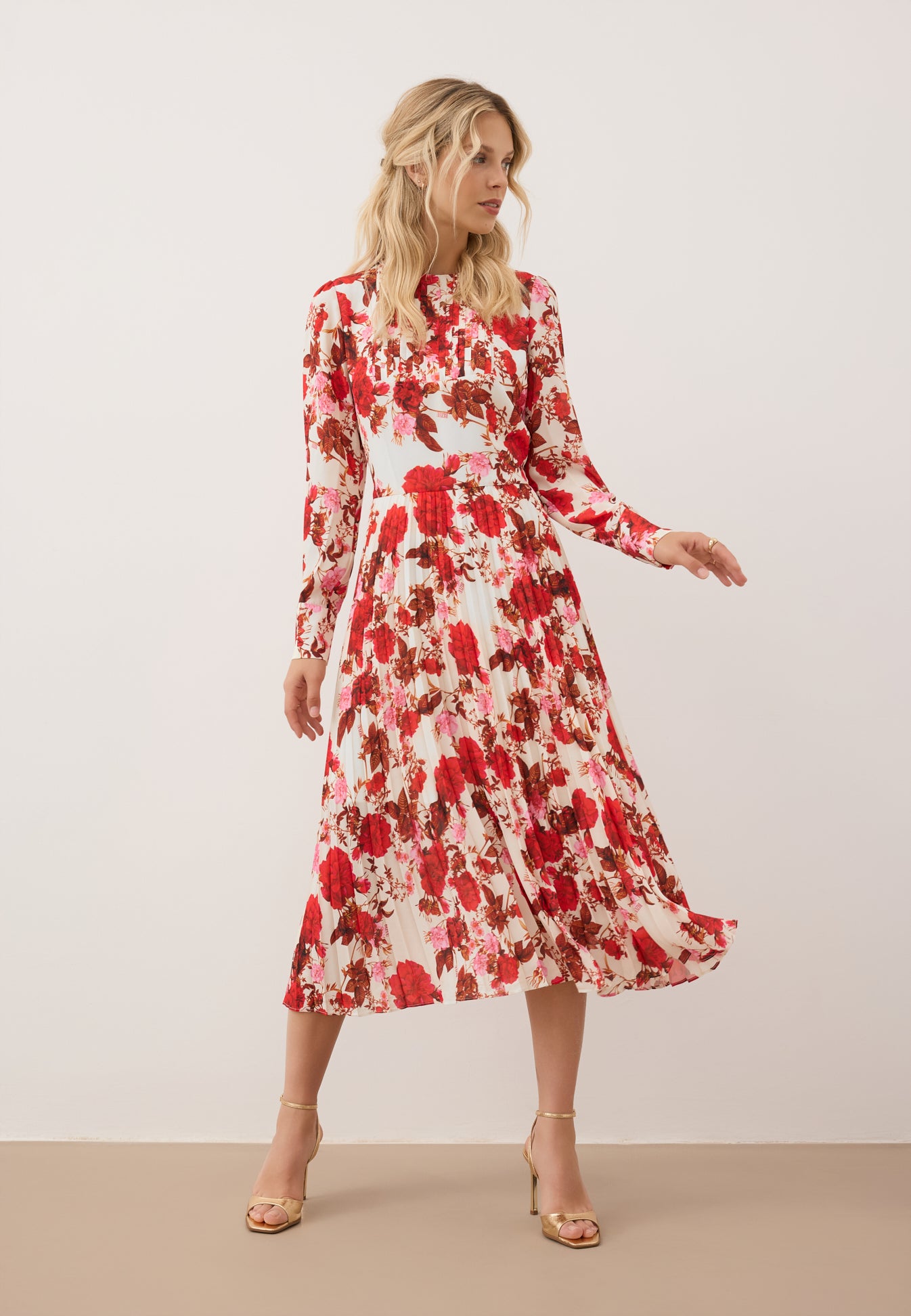 Modelka w ruchu ubrana w midi sukienkę NYLA w kwiatowy print.