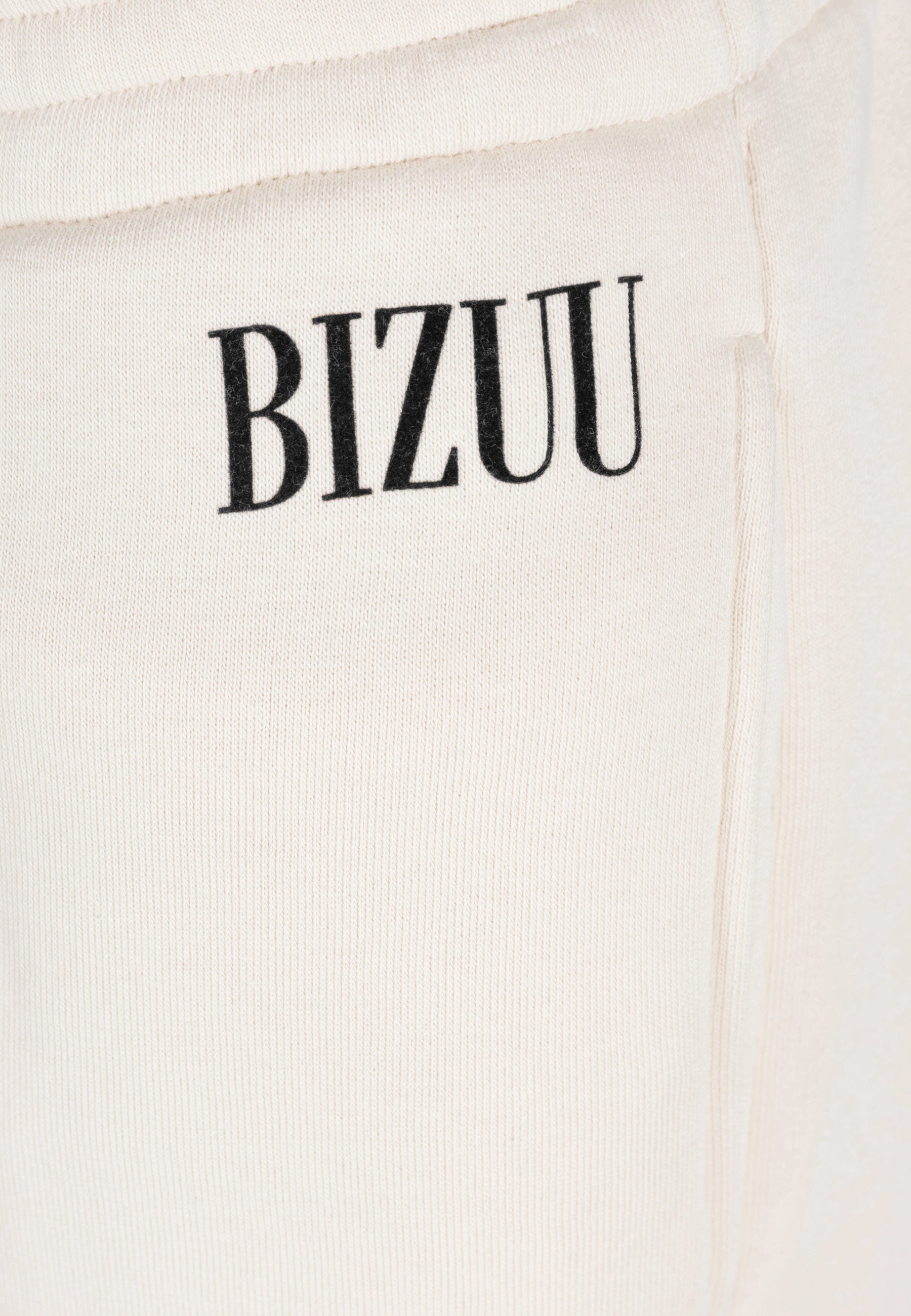 Zbliżenie na czarne logo na przodzie spodni PETRA.