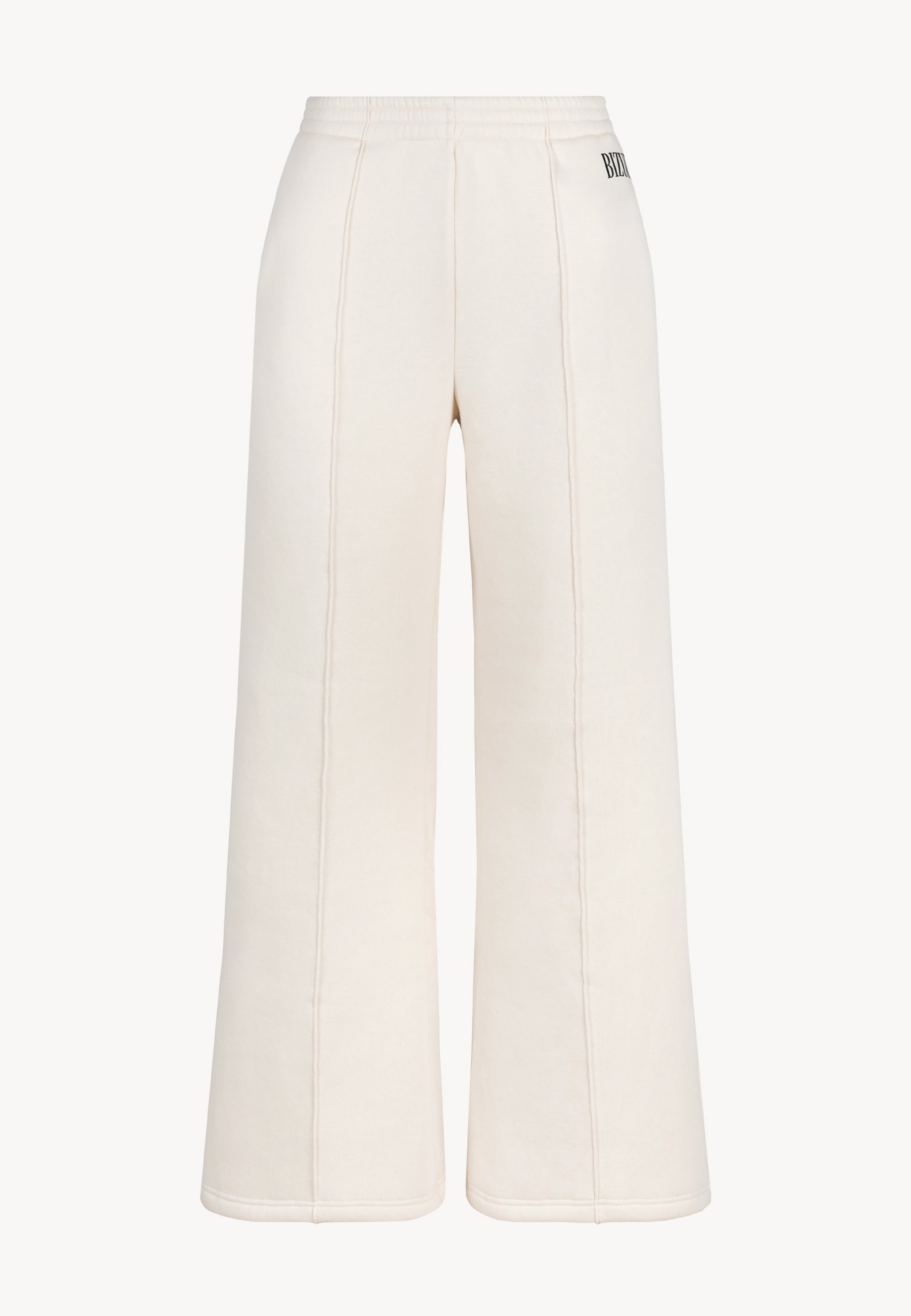 Przód luźnych spodni dresowych PETRA z przeszyciami i logo na kieszeni.