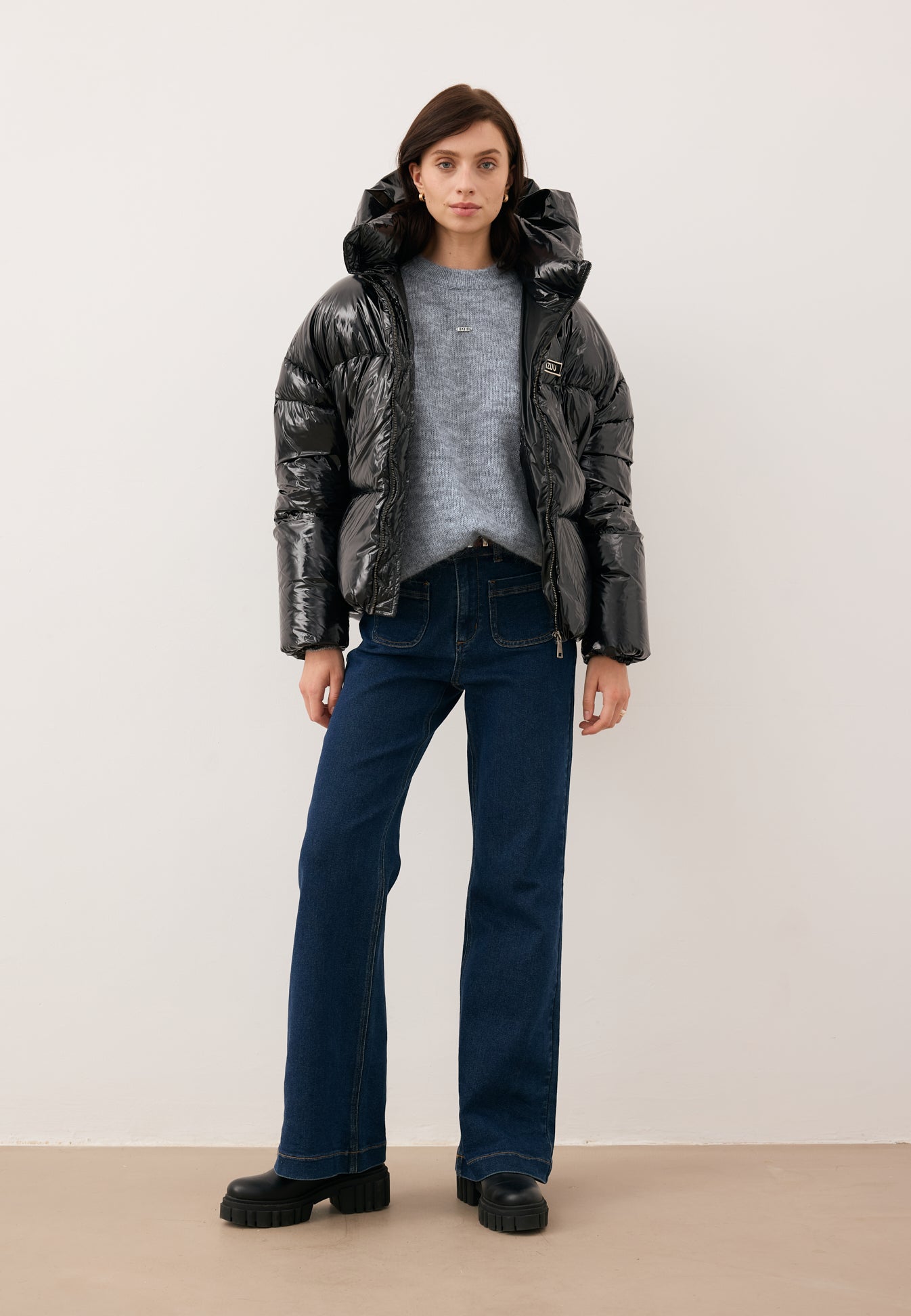 Modelka z rozpiętą kurtką puchową SANYA w kolorze czarnym, ubrana w sweter FAROA oraz spodnie jeansowe DELPHI.