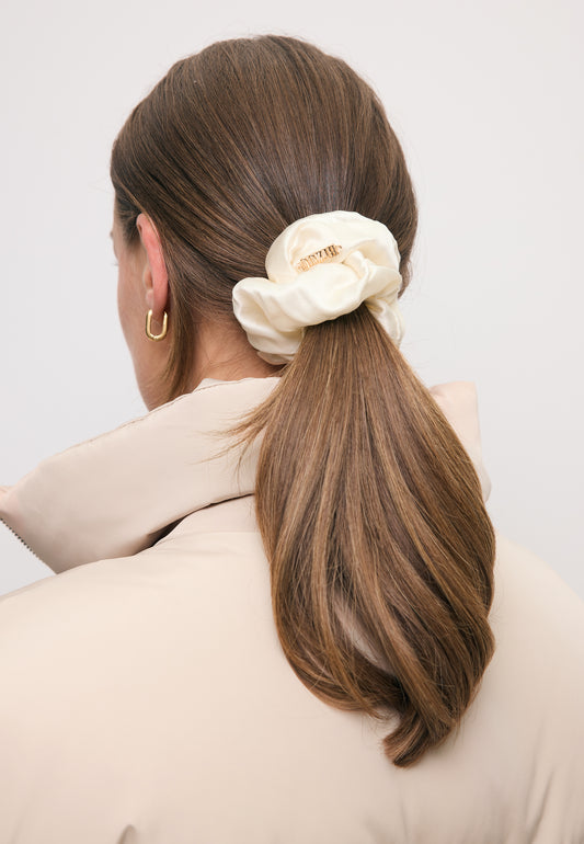 Zbliżenie na włosy modelki przewiązane kremową gumką z jedwabiu SERENA.