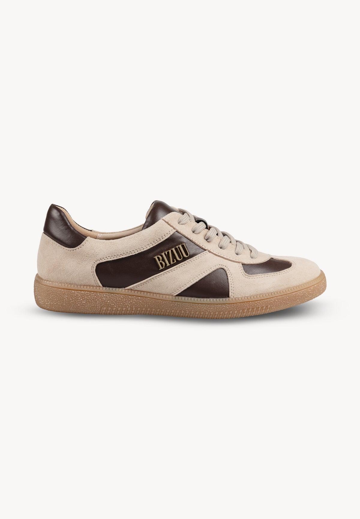 Beżowy sneakers SODDY z brązowymi wstawkami i złotym logo na boku stojący bokiem.