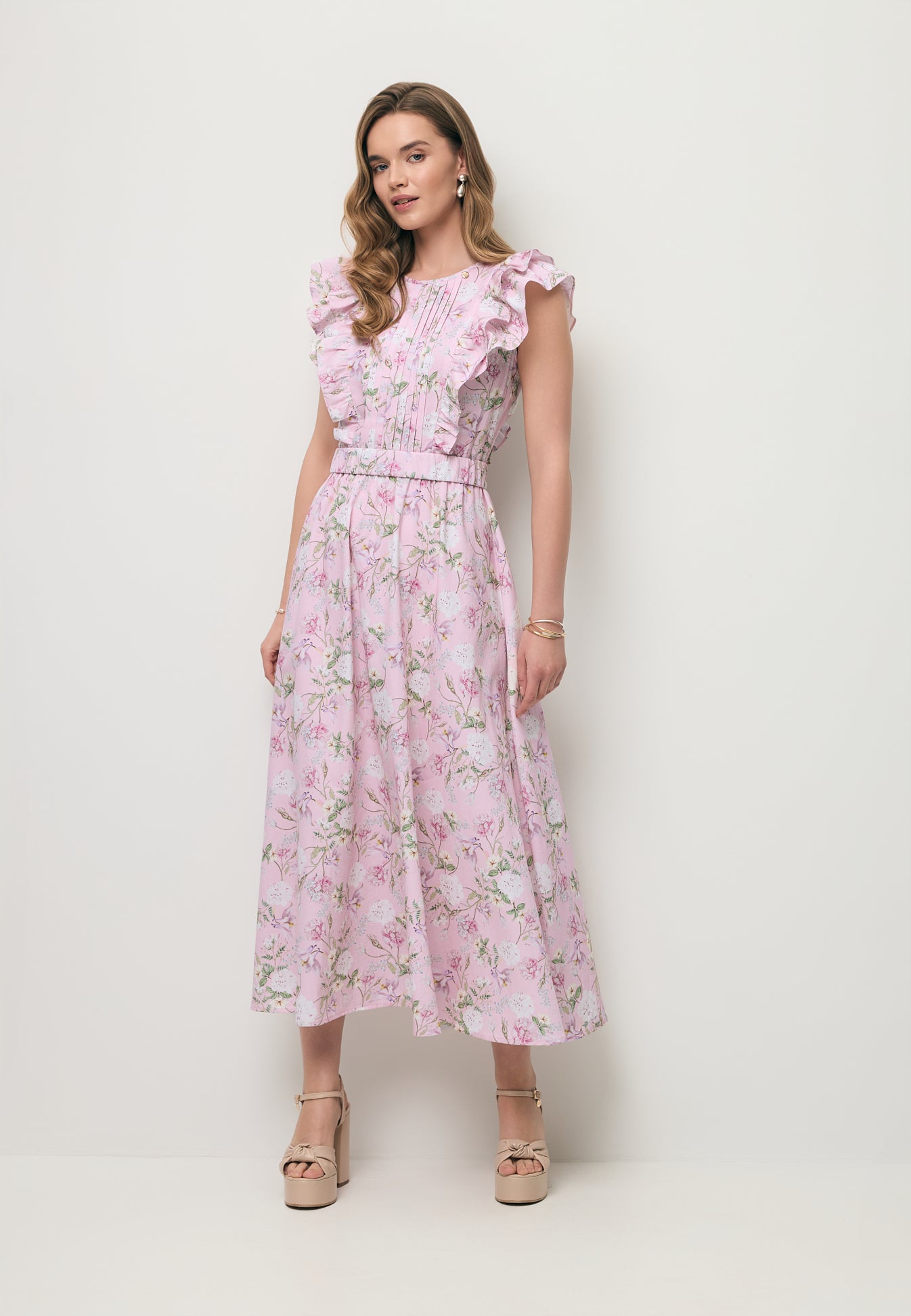 Modelka ubrana w midi sukienkę w różowe kwiatki SOLJA.