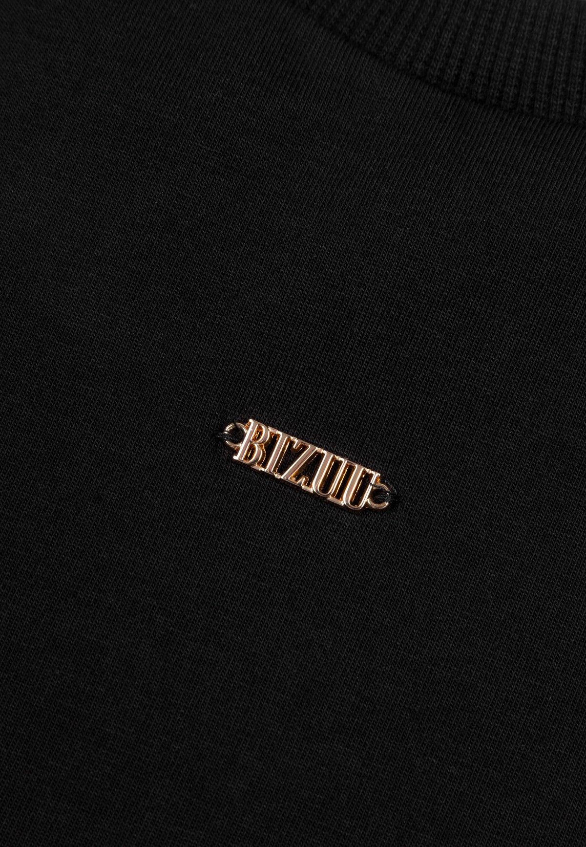 Zbliżenie na ozdobne logo BIZUU w kolorze złotym na przodzie T-shirtu TISHAL.